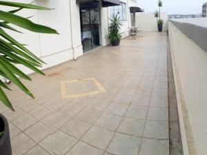 a patio with a tile floor in front of a building at Martha Office Hotel in Bauru