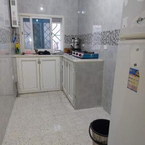 Una cocina con gabinetes blancos y un refrigerador blanco. en country side House, en Irbid