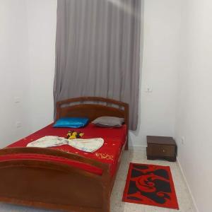 Un dormitorio con una cama con una colcha roja y una manta roja. en country side House, en Irbid