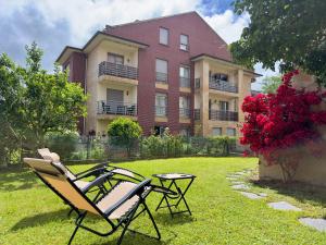 two chairs and a table in front of a building at La Ensenada de Meruelo - 2805 in San Miguel de Meruelo