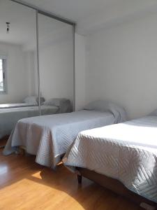 a room with three beds and a mirror at Carilo in Villa Carlos Paz
