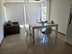 a living room with a table and chairs and a couch at Carilo in Villa Carlos Paz +1 photo