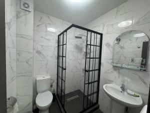 a white bathroom with a toilet and a sink at Casa Cristal Sulina in Sulina