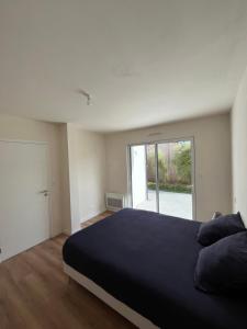 a bedroom with a large bed and a large window at Villa l'estran récente vue mer Plounéour-Brignogan-plages in Plounéour-Trez
