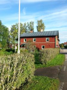 un fienile rosso con tetto nero di Ateljé Vävglädje Butik Bed & Breakfast a Sunnansjö