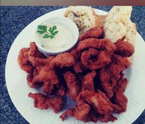 une assiette de nourriture avec des anneaux d'oignon et une sauce trempante dans l'établissement Motel Deslize Uber, à Uberlândia