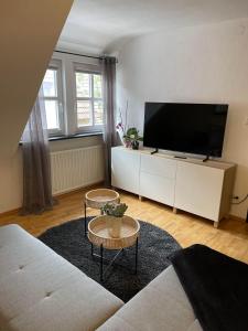 a living room with a large flat screen tv at Ferienwohnung am Kelterplatz in Löwenstein