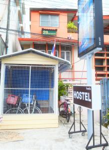 un panneau devant un bâtiment avec une auberge de jeunesse dans l'établissement 28 Rachabutr Hostel, à Ubon Ratchathani