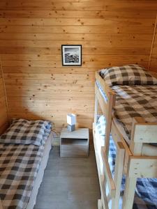 ダルウォボにあるDomki Forest sauna jacuzzi balia Darłowo Darłówko Ruskoの丸太小屋のベッドが2つある寝室