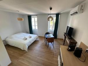 ein Schlafzimmer mit einem Bett und einem Tisch darin in der Unterkunft Comme à la Maison in Crest