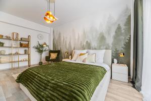 a bedroom with a large bed with a green blanket at Evergreen Escape Apartment Coresi in Braşov
