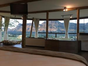 een slaapkamer met uitzicht op een badkuip en de bergen bij Casa 422 - Loft Oliveira in Santana do Riacho