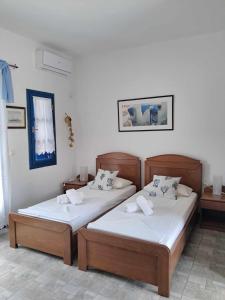 two beds are in a room with at Aegean Star Hotel in Karavostasi