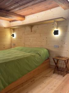 a bedroom with a green bed in a cabin at Stilish wooden chalet fully renovated near the lifts in Alagna Valsesia