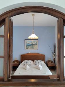 a bedroom with a large white bed with pillows at Aegean Star Hotel in Karavostasi