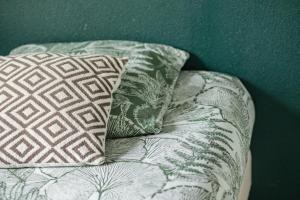 a couch with two pillows on top of it at Les Cocons de Lourdes in Lourdes +25 photos
