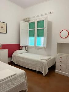 a bedroom with two beds and a window at Apartamento con encanto a 2 minutos de la playa in Sant Feliu de Guixols
