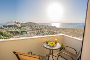 a balcony with a table with fruit and orange juice at Panorama in Elafonisi