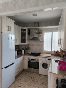 a kitchen with a white refrigerator and a dishwasher at Villa Coral in Chiclana de la Frontera