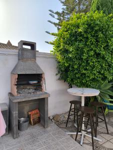 an outdoor fireplace with two chairs and a table at Villa Coral in Chiclana de la Frontera