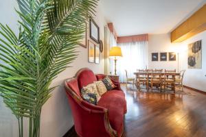 a living room with red chairs and a palm tree at Guittone18 in Arezzo