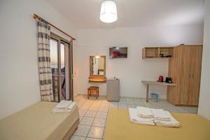 a room with a bed and a table and a refrigerator at Panorama in Elafonisi