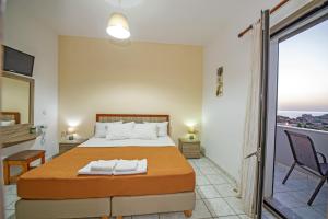 a bedroom with a bed and a balcony at Panorama in Elafonisi