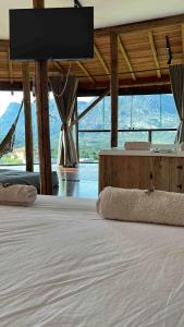 een slaapkamer met een groot bed en een flatscreen-tv bij Casa 422 - Loft Jasmim in Santana do Riacho