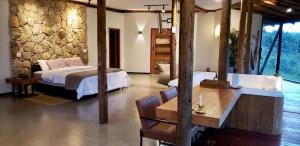 een slaapkamer met een bed, een bureau en een bad bij Casa 422 - Loft Jasmim in Santana do Riacho