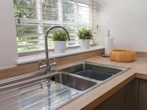 a stainless steel sink in a kitchen with a window at Rooftops Cottage in Whitby +39 photos