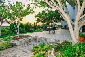 a patio with a table and chairs and trees at Panorama in Elafonisi