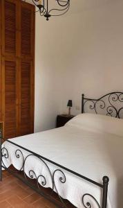 ein Schlafzimmer mit einem großen weißen Bett mit einem Kronleuchter in der Unterkunft Villa with BBQ and Private Garden - Shared Pool and Tennis court in Ansedónia