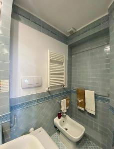 ein Badezimmer mit einer weißen Toilette und einem Waschbecken in der Unterkunft Villa with BBQ and Private Garden - Shared Pool and Tennis court in Ansedónia