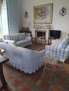 ein Wohnzimmer mit zwei Sofas und einem Kamin in der Unterkunft Villa with BBQ and Private Garden - Shared Pool and Tennis court in Ansedónia