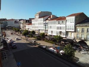 a city street with buildings and a street with cars at Pensión La Plaza in Betanzos +29 photos