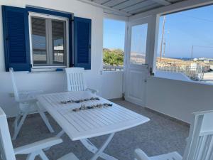 a white table and chairs on a porch at Karras House in Kimolos