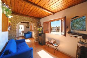 een woonkamer met een blauwe bank en een tv bij Casa Mare in Praiano