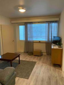 a living room with a table and a large window at Huoneisto lähellä keskustaa in Pieksamaki