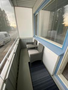a balcony with two chairs and a window at Huoneisto lähellä keskustaa in Pieksamaki