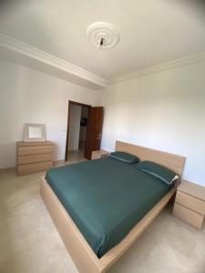 een slaapkamer met een groot bed met blauwe lakens bij Apparemment Noura in Tetouan
