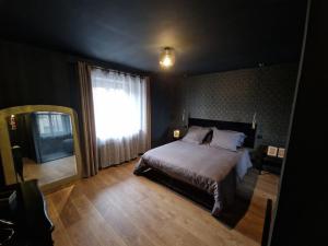 a bedroom with a bed and a large window at Maison 2 à 4 pers Spa Sauna in Saint-Victurnien