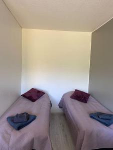 two beds in a room with purple sheets and towels at Viihtyisä huoneisto lähellä palveluita in Pieksamaki