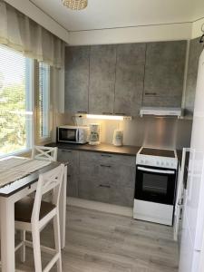 a kitchen with a white stove top oven next to a counter at Viihtyisä huoneisto lähellä palveluita in Pieksamaki