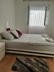 a bedroom with a large bed with a window at Apartmani Pantovic - Apartman 1 in Trebinje +9 photos