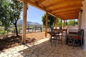 a wooden pergola with a table and chairs on a patio at Fysis Panorama spectacular view in Porto Rafti