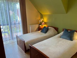 two beds sitting in a room with a window at Apartamenty NAUTICA Rowy, 150m od plaży in Rowy