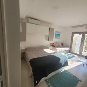 Un dormitorio pequeño con una cama y un sofá. en Gwyneth casa de playa, en Puerto Madryn