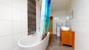 une salle de bain avec une baignoire et un lavabo dans l'établissement Le nid perché Mulhouse, à Mulhouse