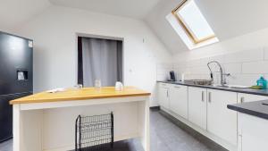 une cuisine avec des armoires blanches et un comptoir en bois dans l'établissement Le nid perché Mulhouse, à Mulhouse 8 autres photos