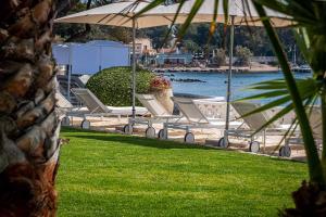 a row of lawn chairs sitting next to a body of water at La Villa Mauresque in Saint-Raphaël
